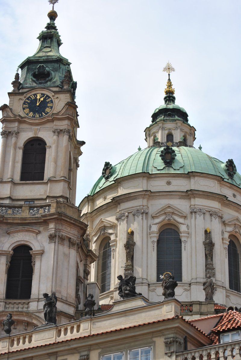A church with a green dome and a clock tower