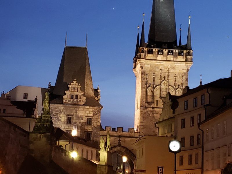 A clock tower is lit up at night in a city