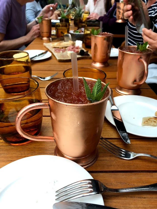 A group of people are sitting at a table with drinks and plates