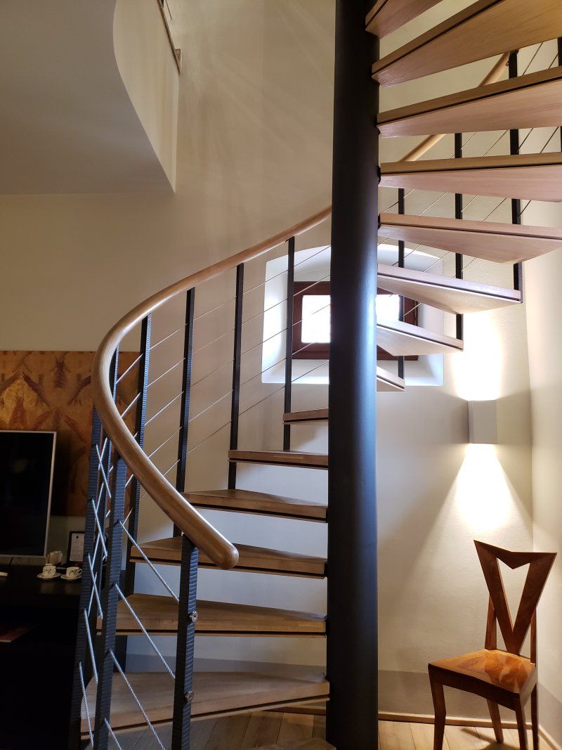 A spiral staircase in a living room with a chair