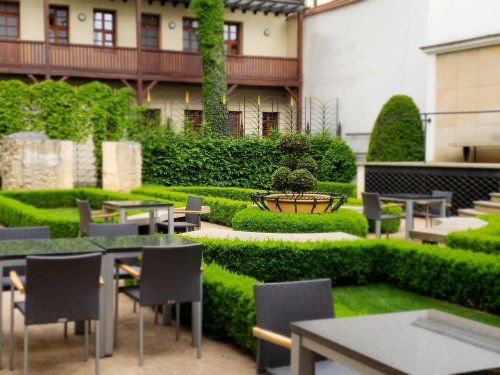 A garden with tables and chairs in front of a building