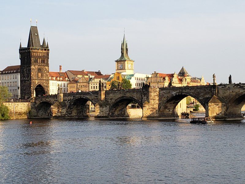 A bridge over a river with a city in the background