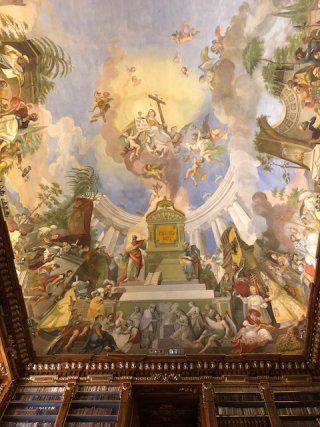 There is a painting on the ceiling of a building.
