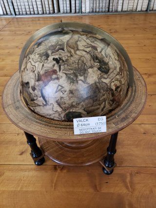 A globe is sitting on top of a wooden table.