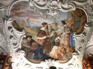 A painting on the ceiling of a church of a group of people.