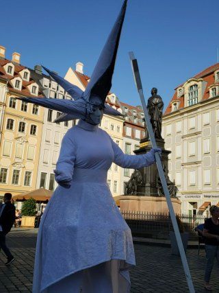 A woman in a white dress is holding a pole