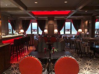 A large room with tables and chairs and a red light on the ceiling.