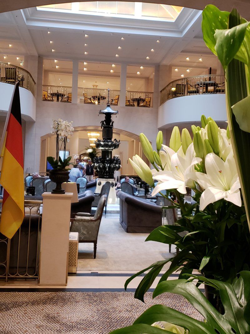 A hotel lobby with a flag and flowers in the foreground