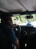 A man wearing sunglasses is driving a car