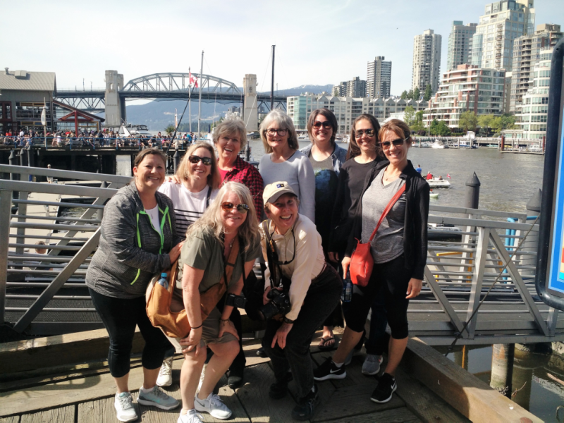 A group of women are posing for a picture on a dock