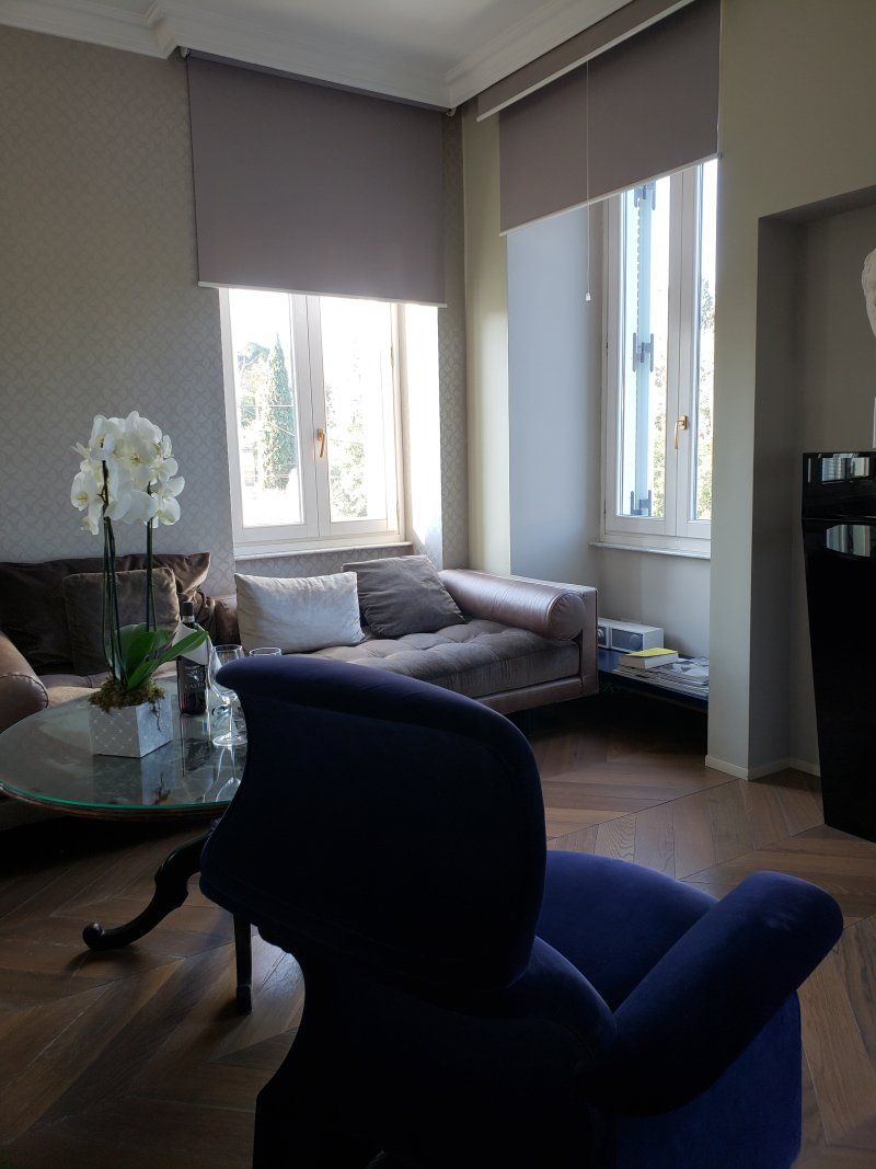 A living room with a couch , chair , table and window.