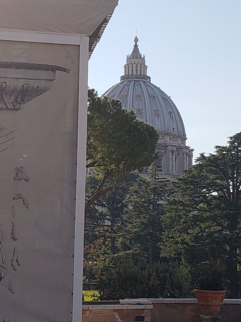 A view of a dome from a balcony with trees in the foreground.