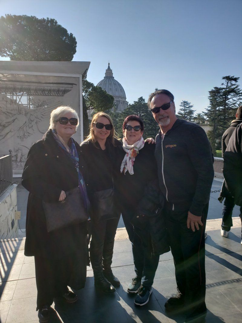 A group of people are posing for a picture in front of a dome.