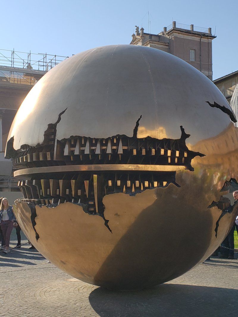 A large sphere with a reflection of a city in it