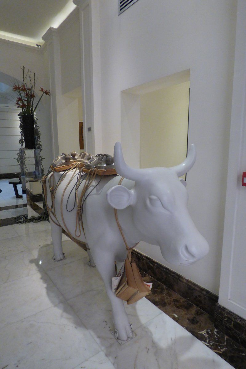 A white statue of a bull with a saddle on it