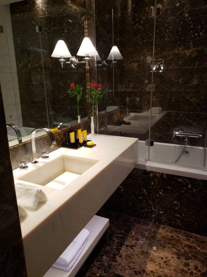 A bathroom with a sink , tub and mirror