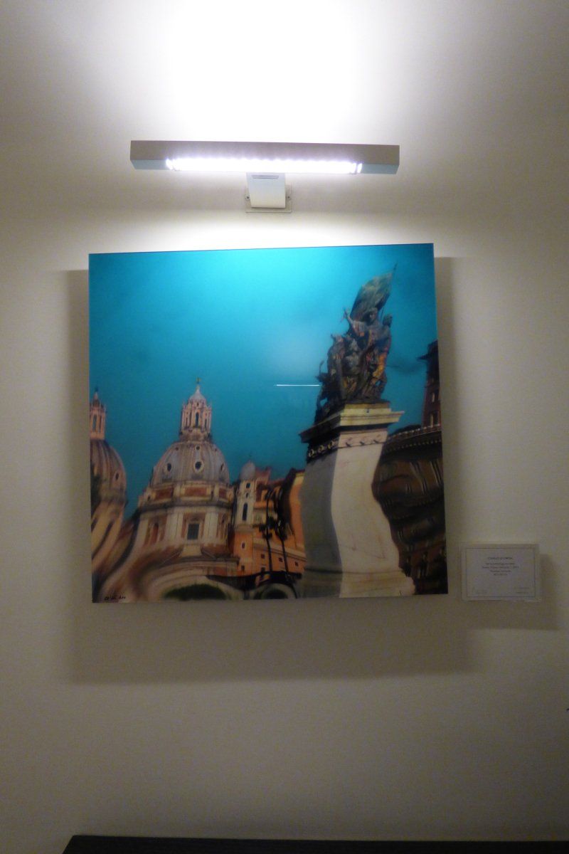 A painting on a wall with a light above it
