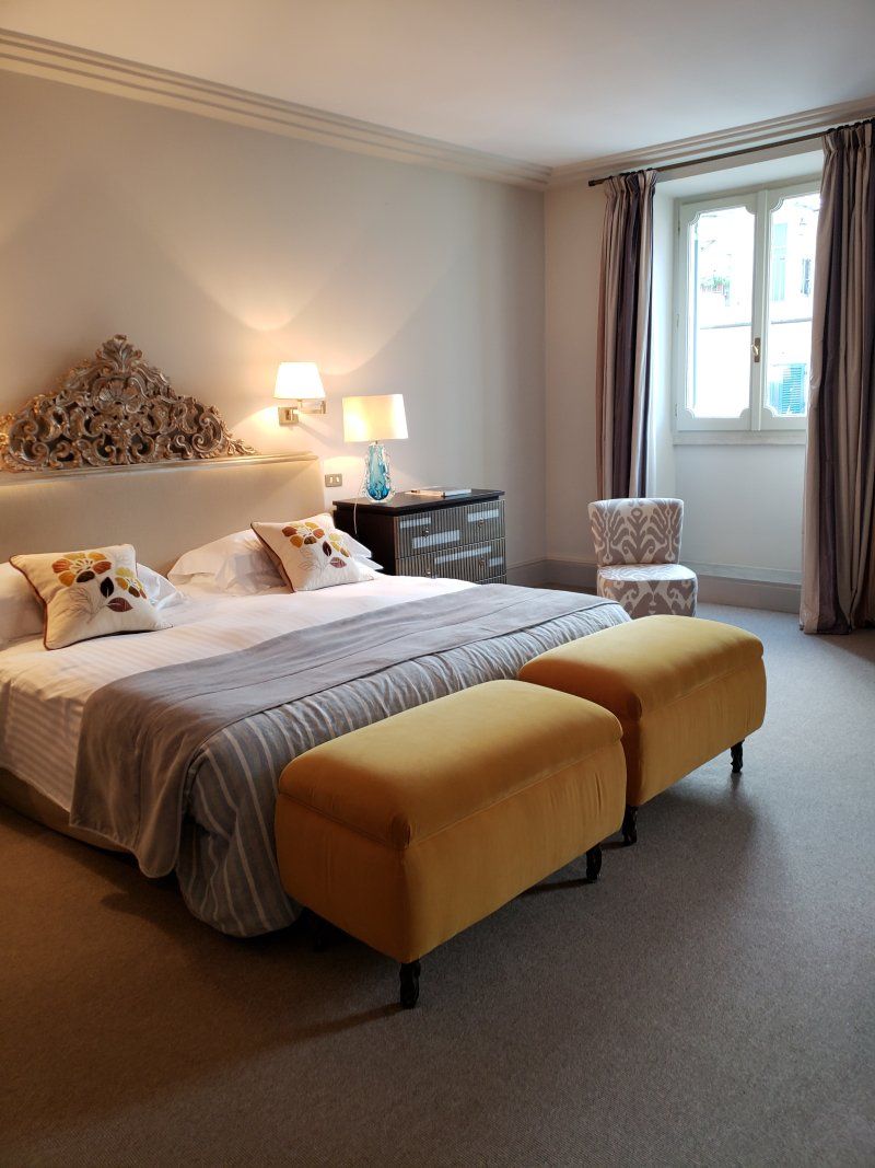 A bedroom with a large bed and two yellow benches