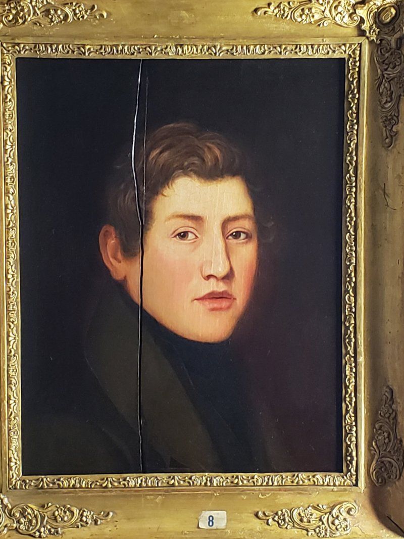 A portrait of a young man in a gold frame