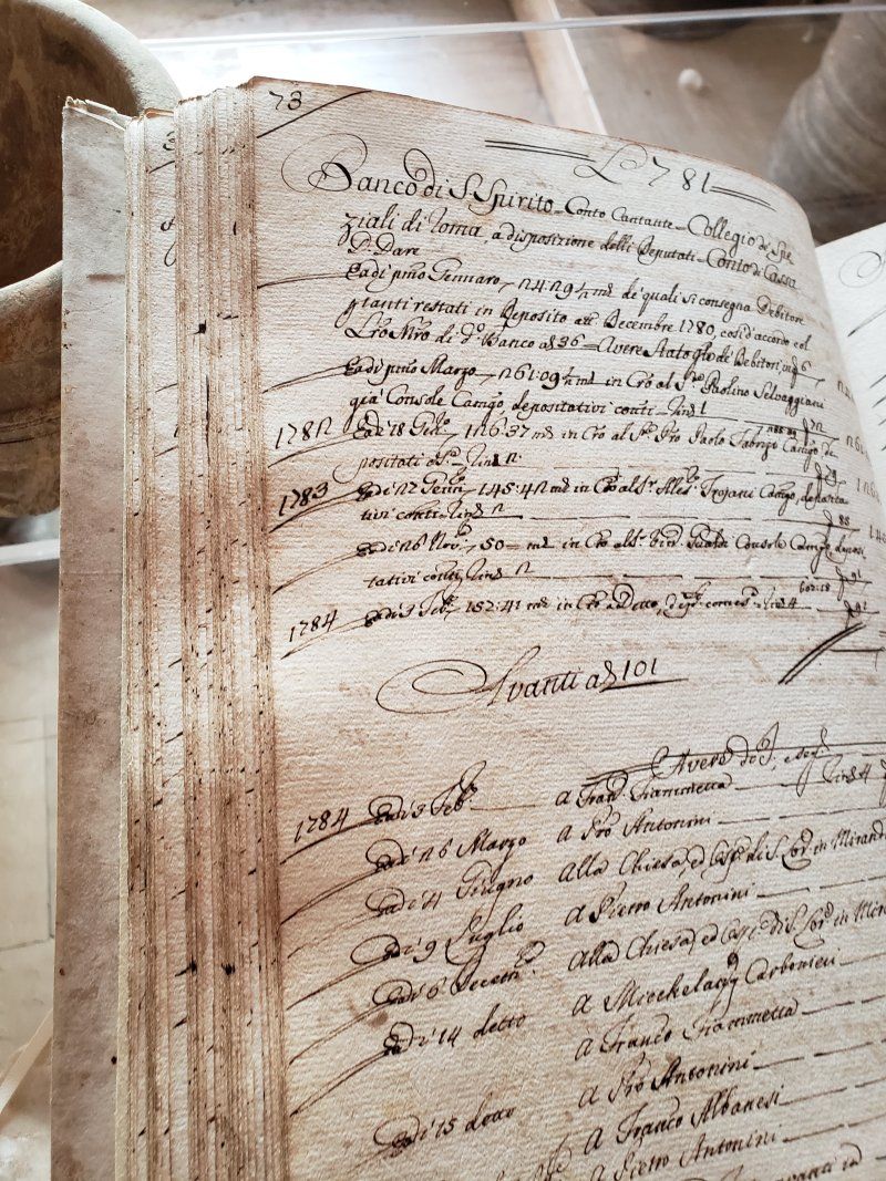 An old book is open to a page with handwriting on it.