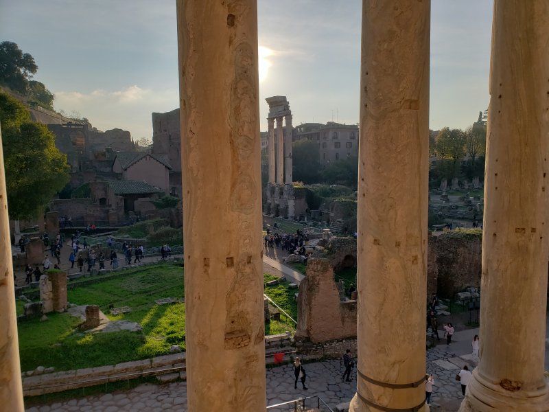 A view of the roman forum from a balcony with columns.