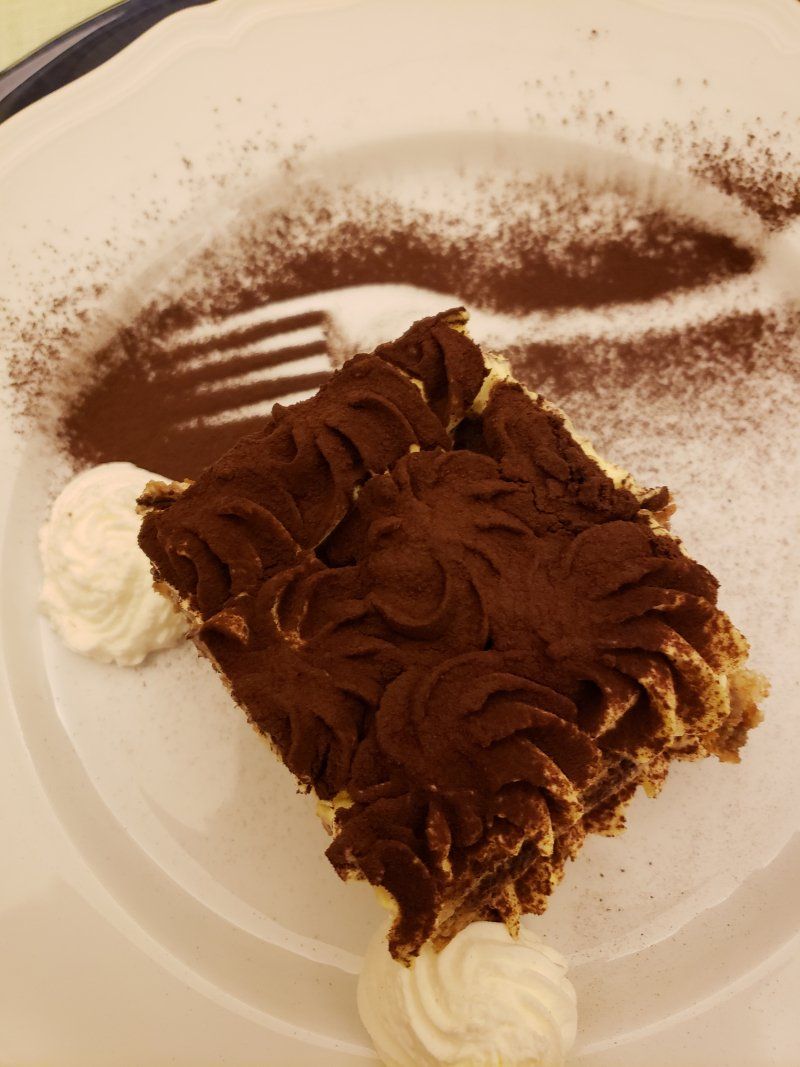 A piece of chocolate cake with whipped cream on a plate with a fork