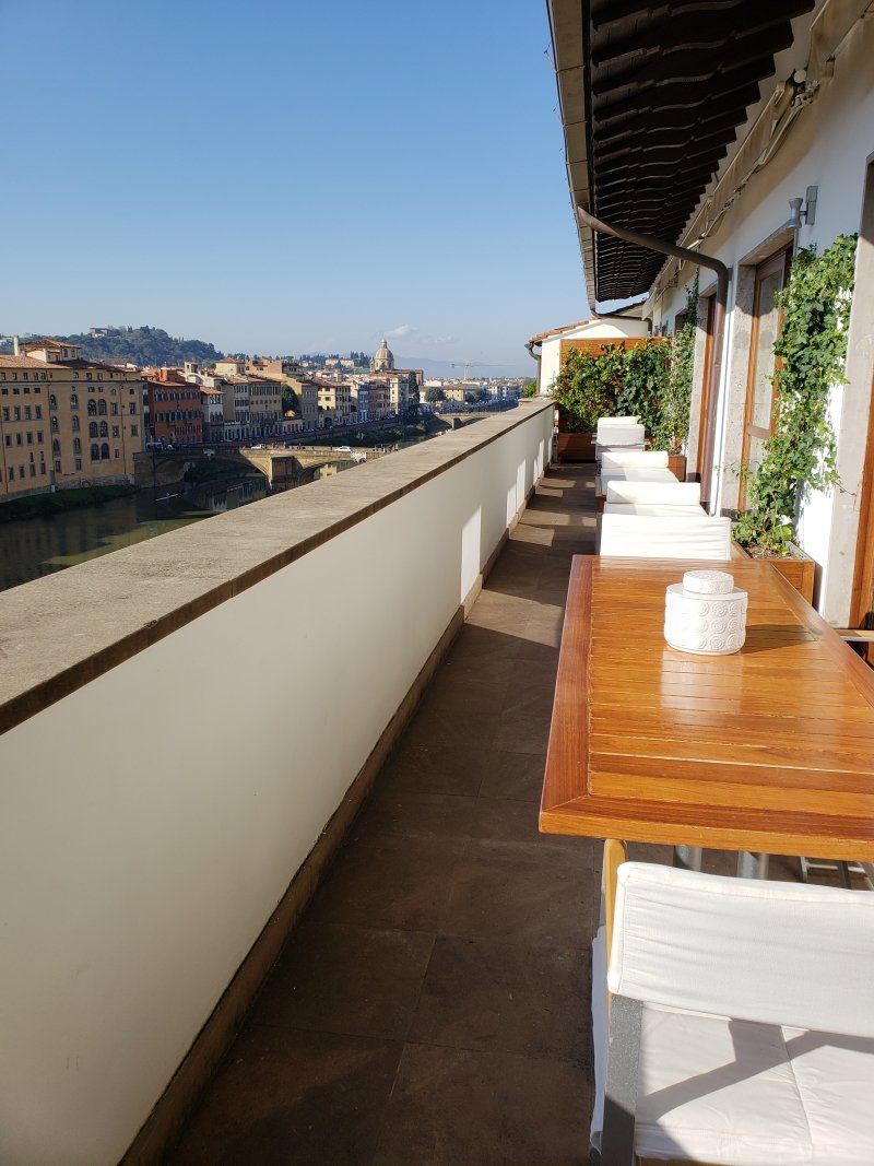 A balcony with a table and chairs and a view of a city.