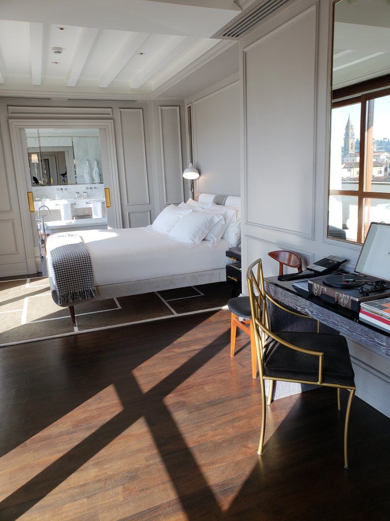 A hotel room with a large bed and a desk