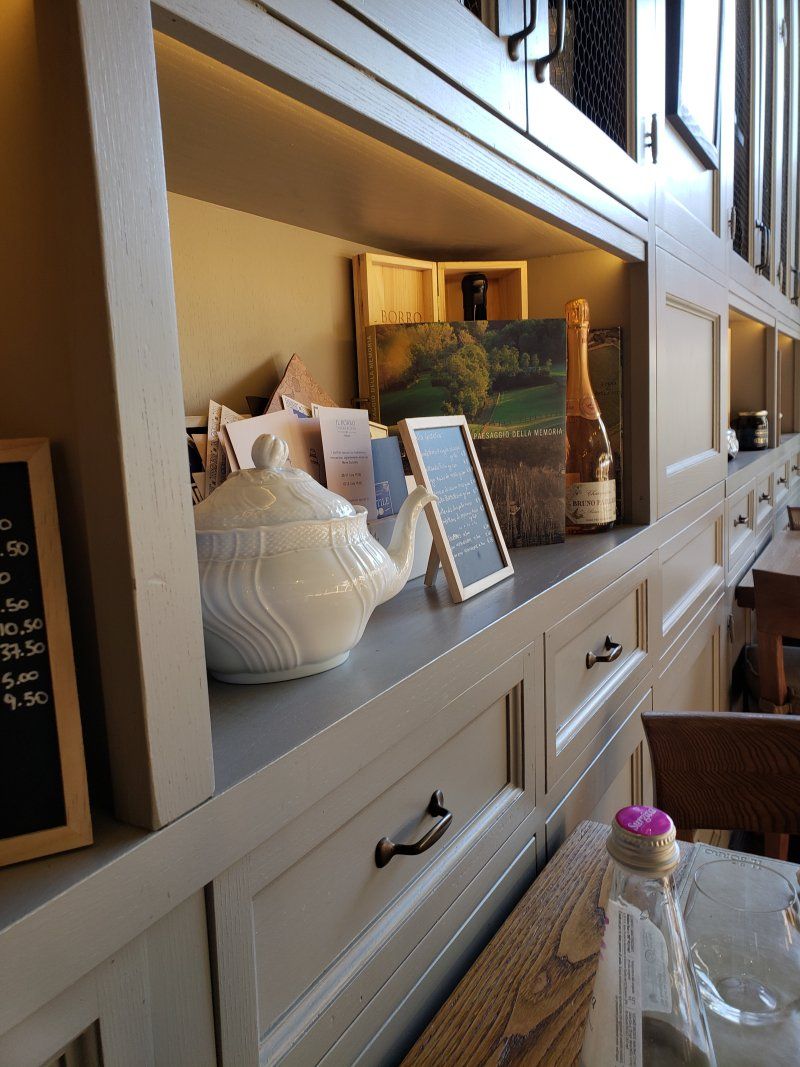 A shelf with a teapot and a bottle on it