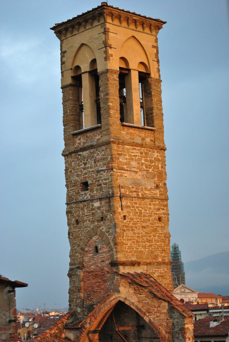 A large stone tower with a bell on top of it