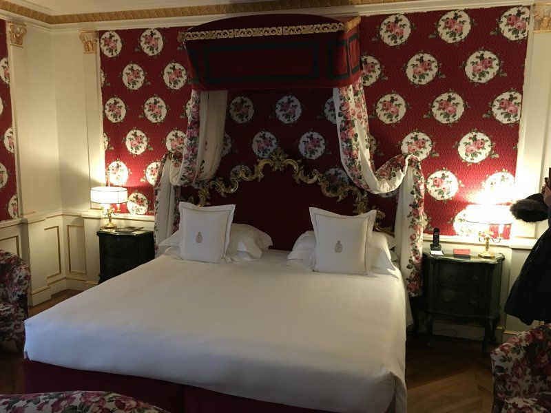 A bedroom with a canopy bed and red walls