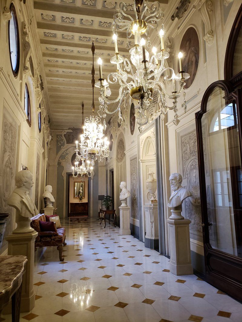 A long hallway with a chandelier hanging from the ceiling.