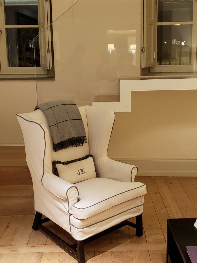 A white chair in a living room with a blanket on it