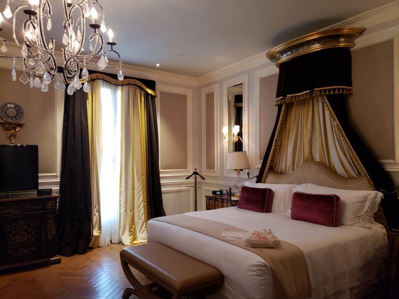 A bedroom with a large bed and a chandelier