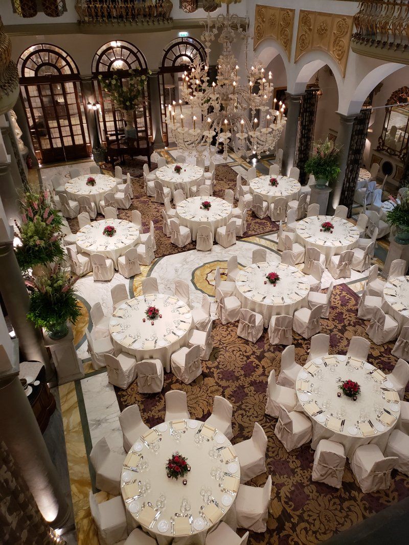 A large room filled with tables and chairs and a chandelier.
