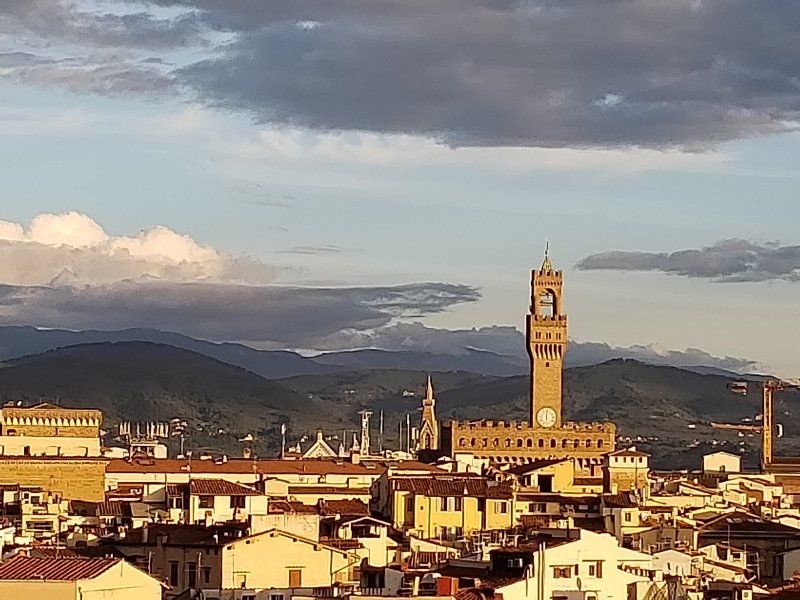 A city with a clock tower and mountains in the background