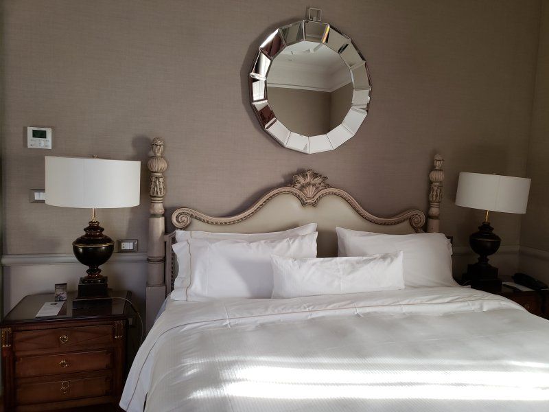 A bedroom with a bed and a mirror on the wall