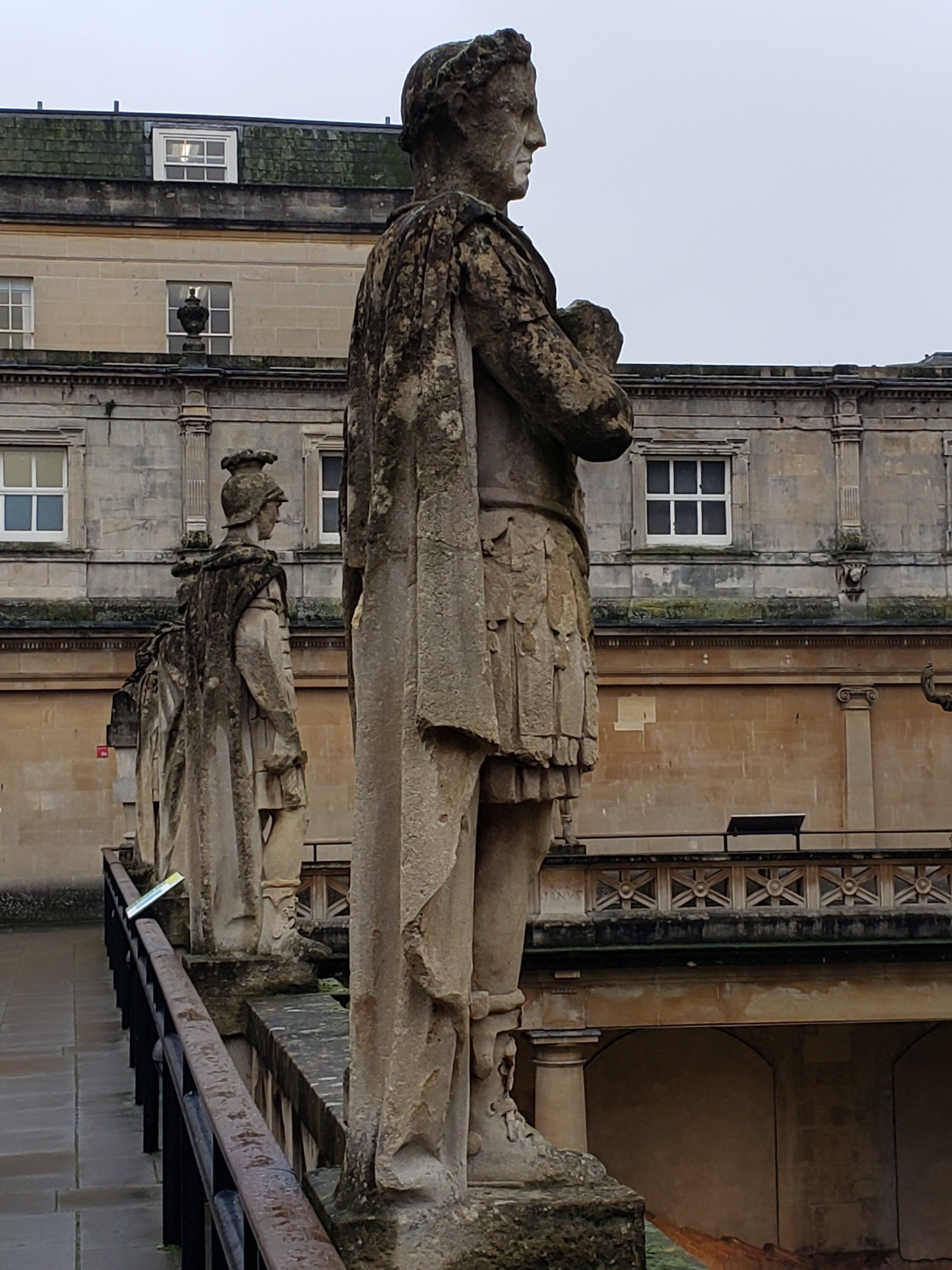 A statue of a man standing in front of a building