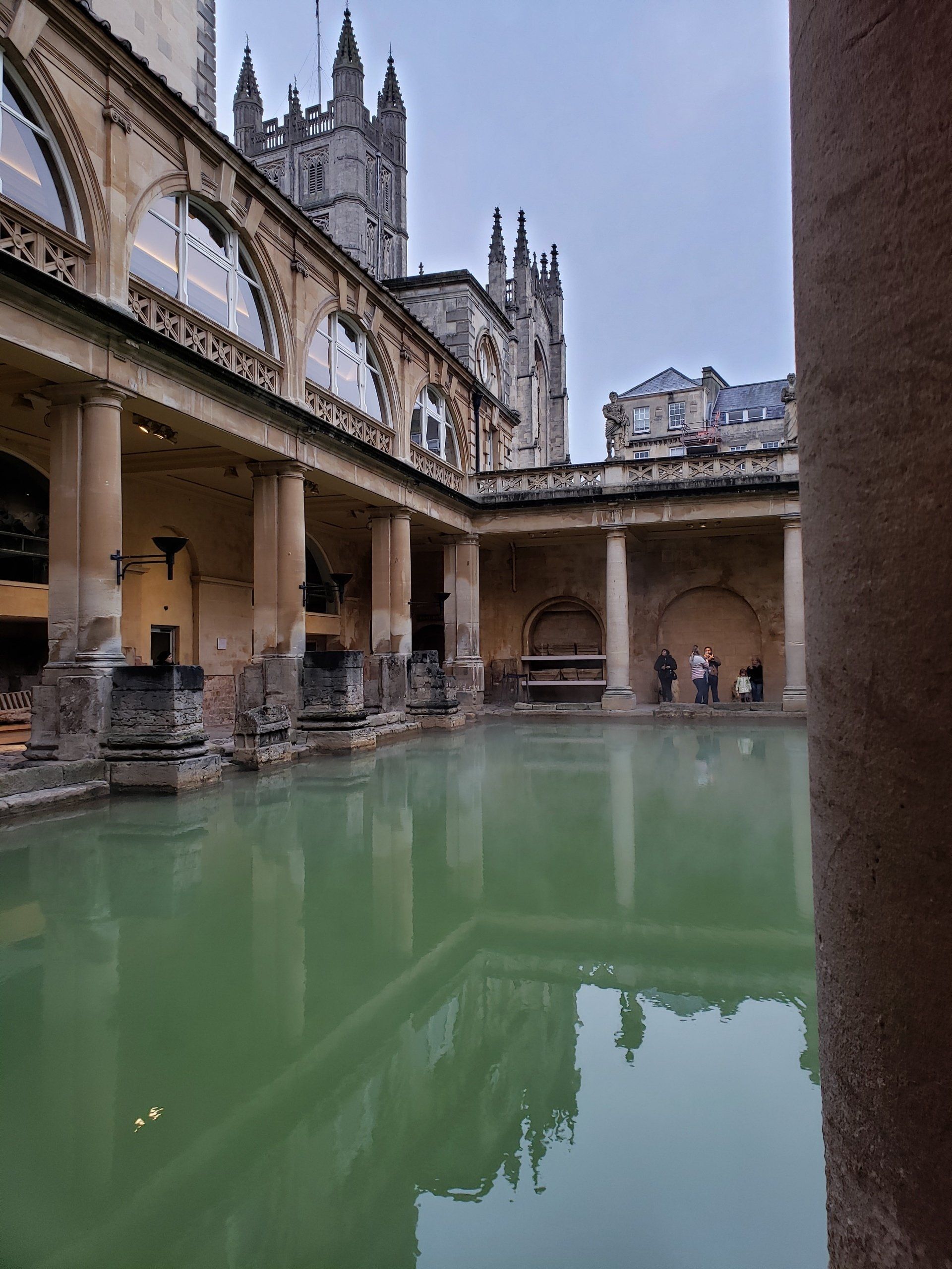 A large pool of water in the middle of a building with a castle in the background.