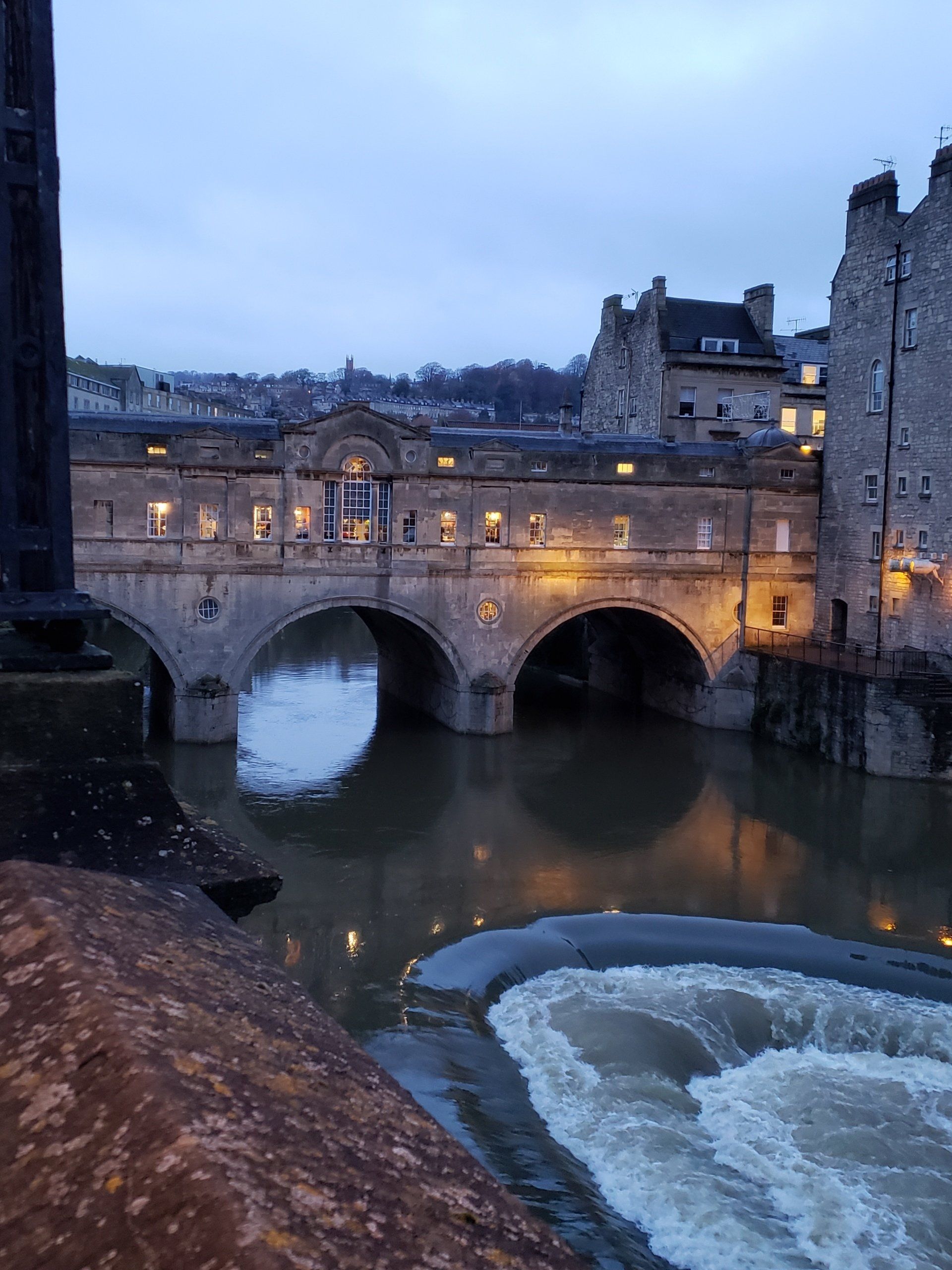 A bridge over a river in a city at night.