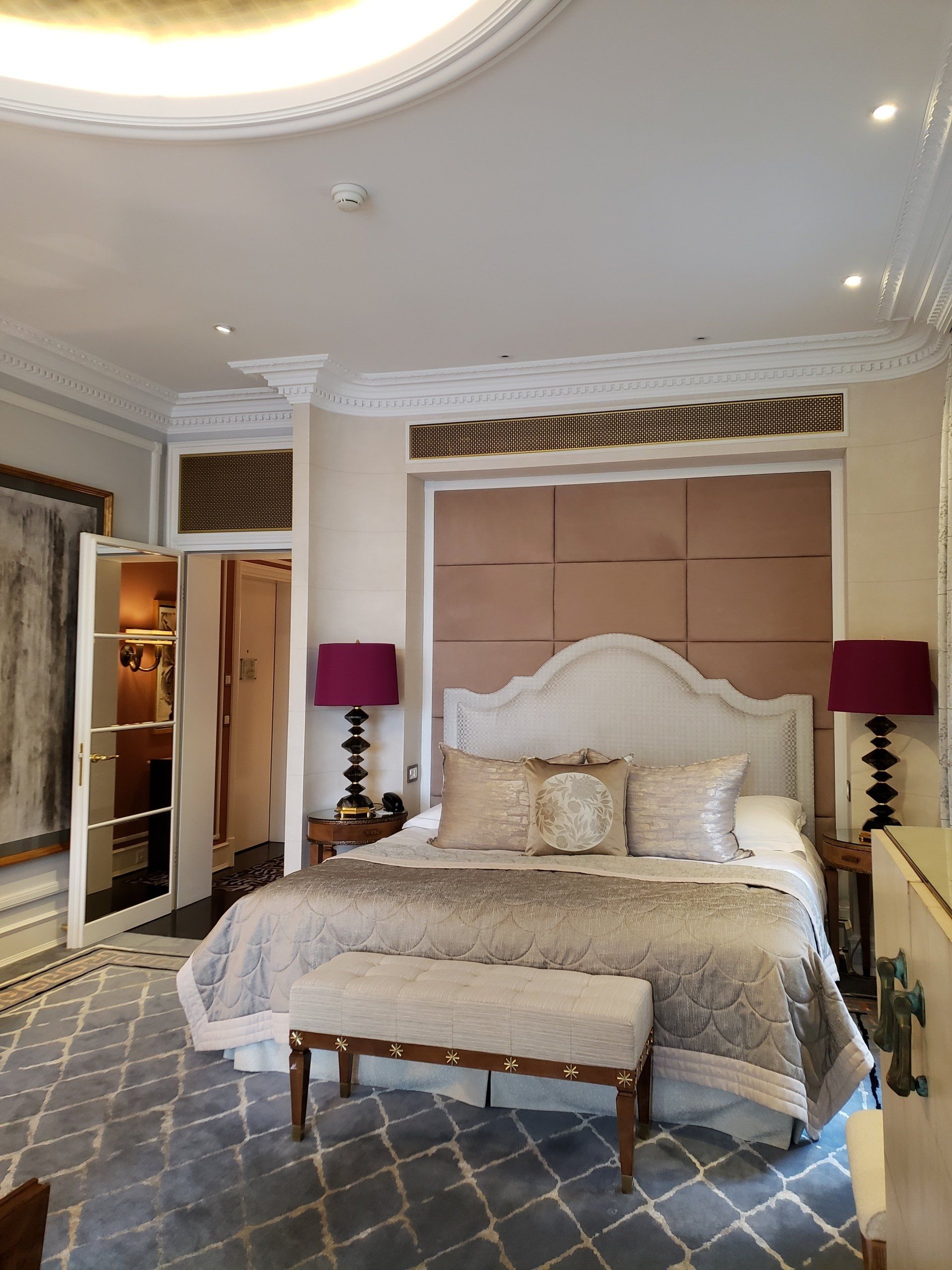 A bedroom with a large bed and a bench.