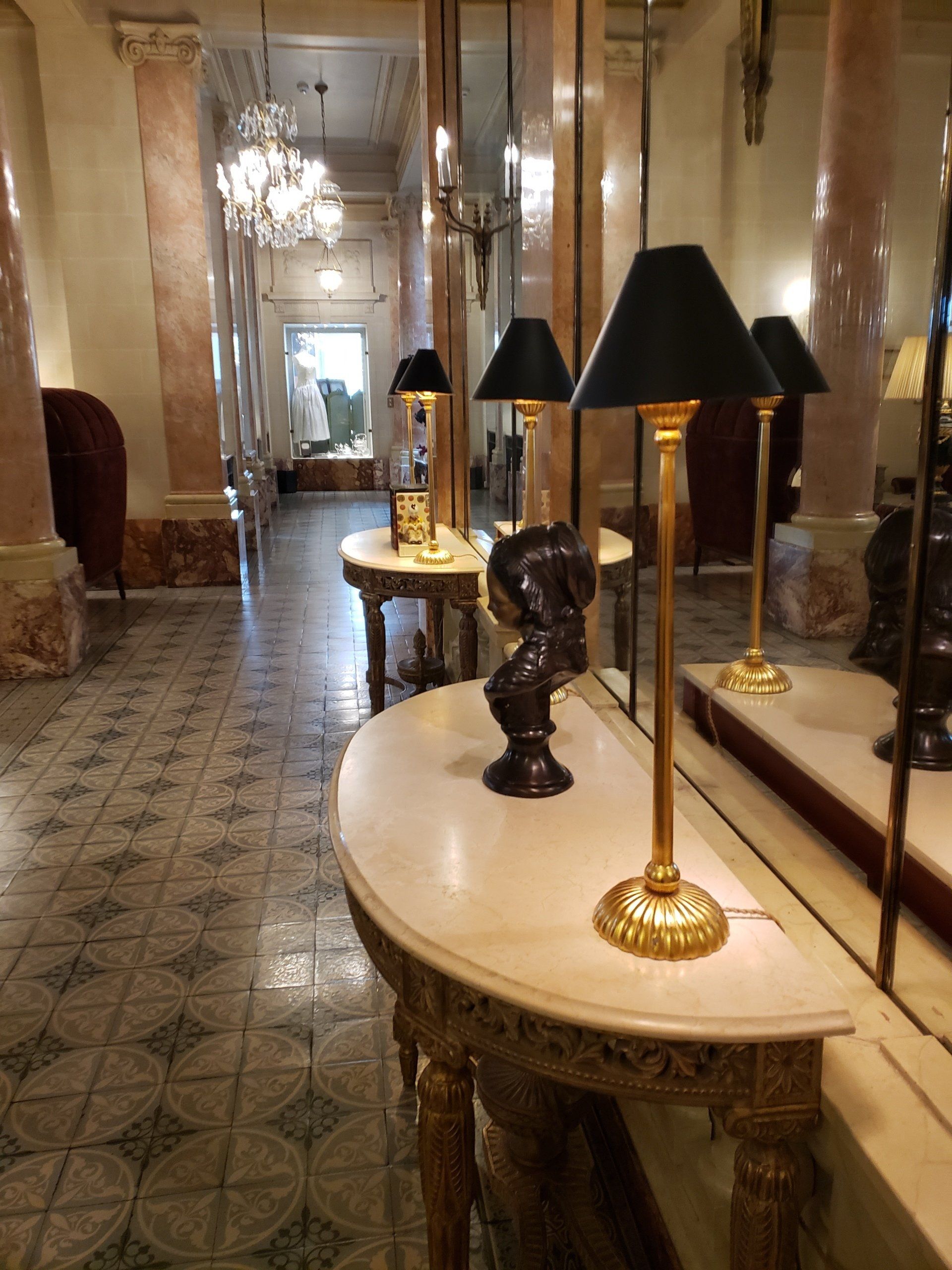 A hallway with tables and lamps in it