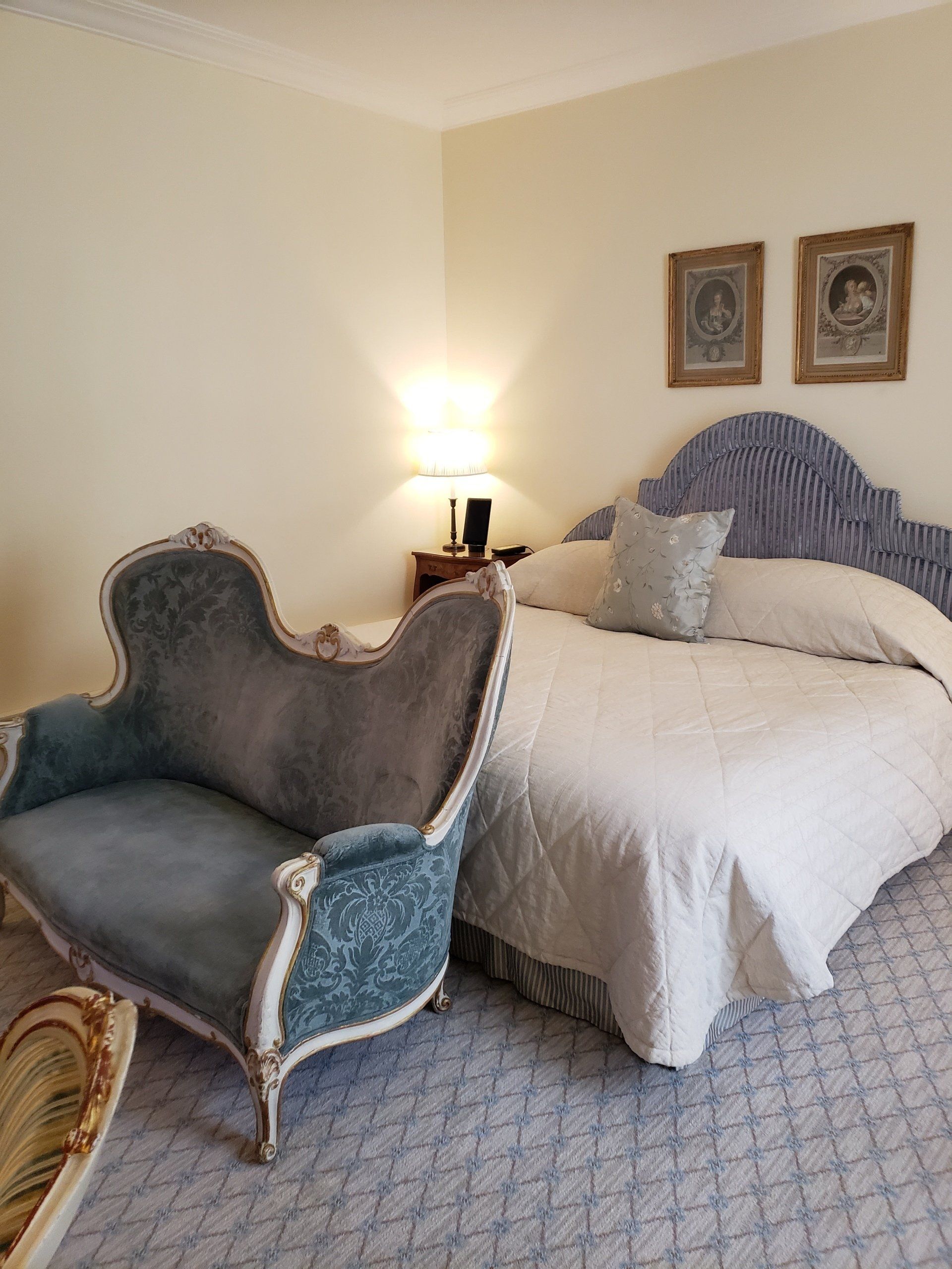 A bedroom with a large bed and a blue chair