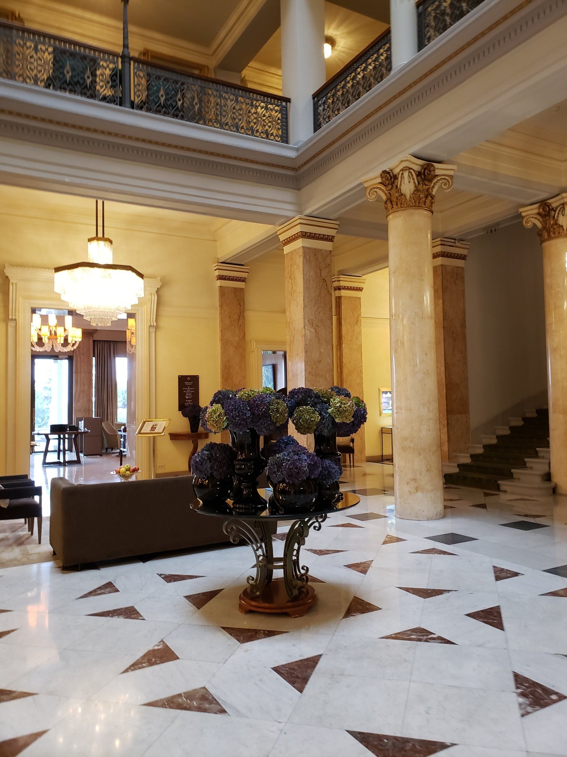 A large room with a couch and a vase of flowers