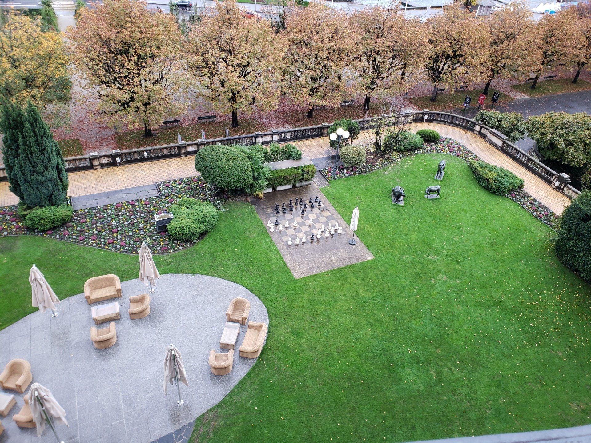 An aerial view of a lush green garden with a chess board in the middle.