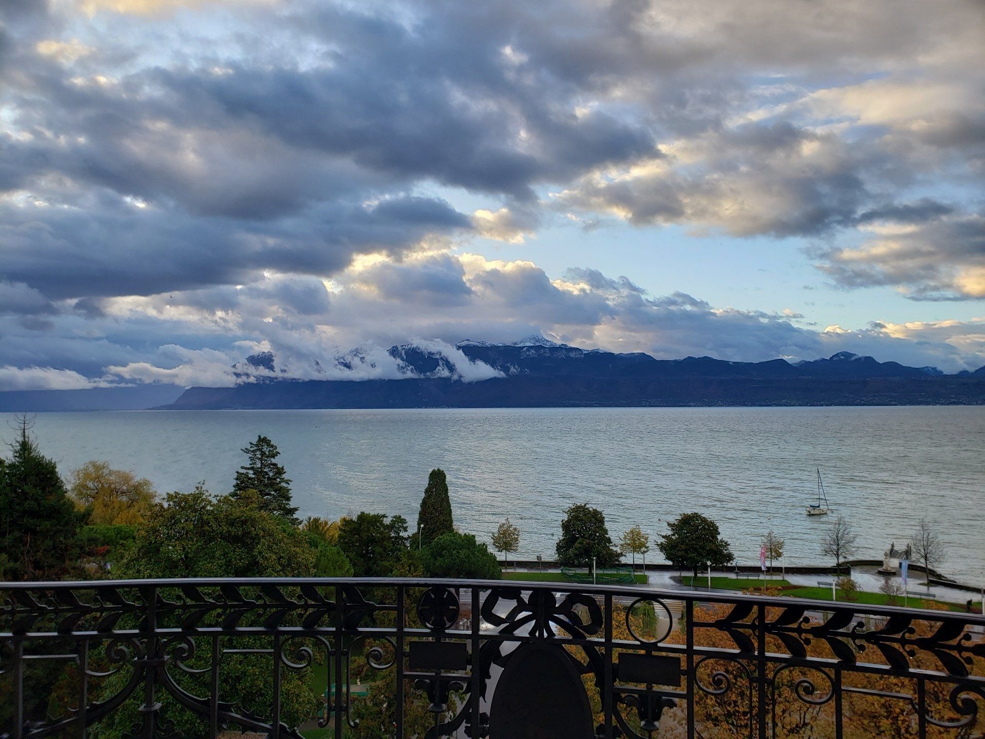 A balcony overlooking a lake with mountains in the background