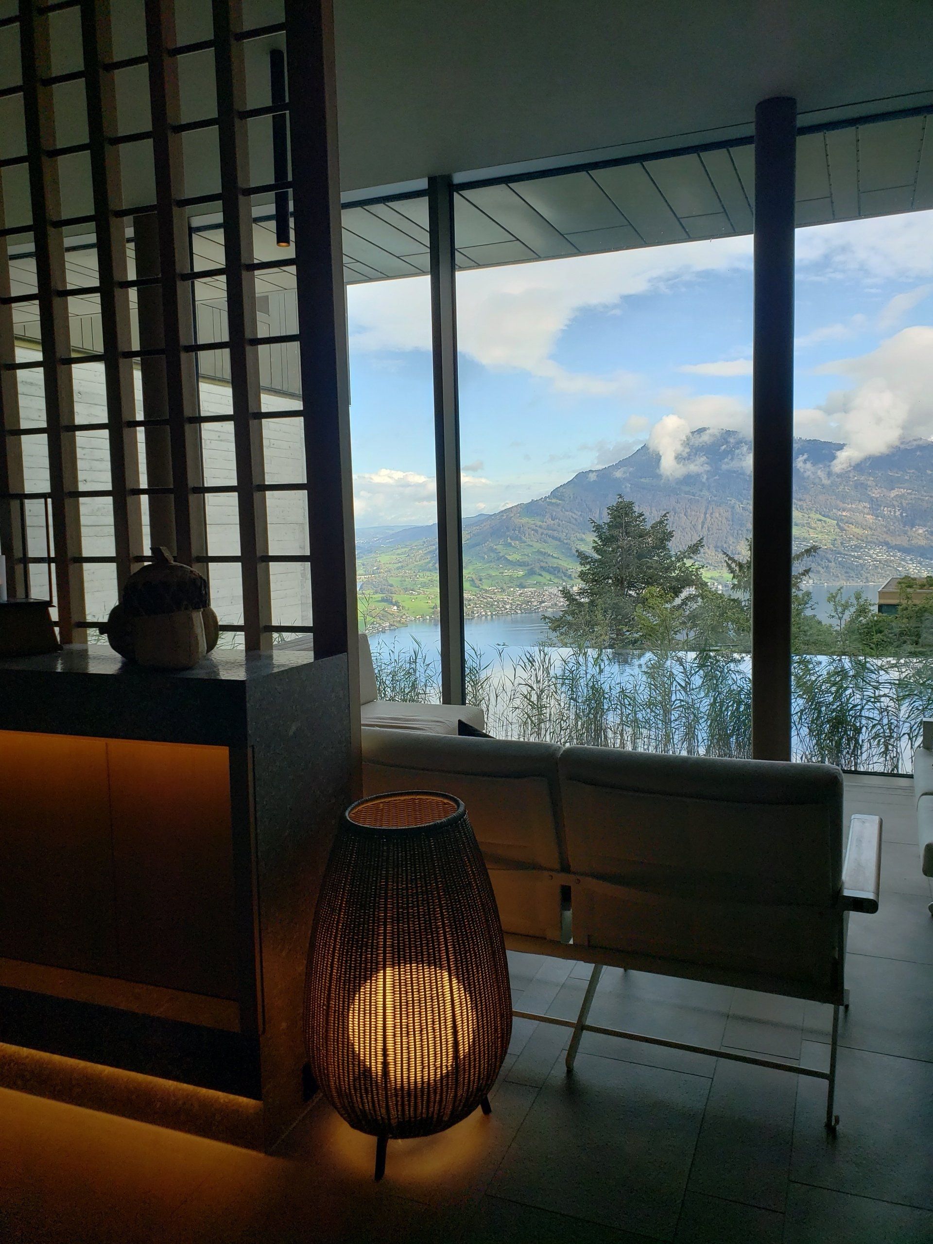 A room with a view of a lake and mountains.