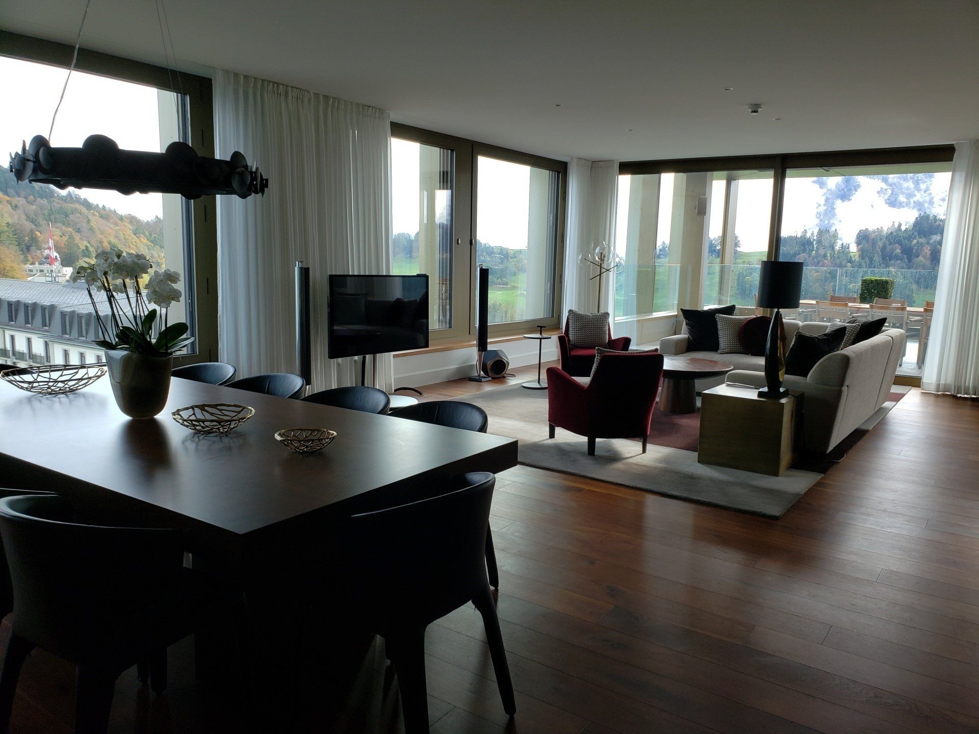 A living room with a table and chairs and a flat screen tv