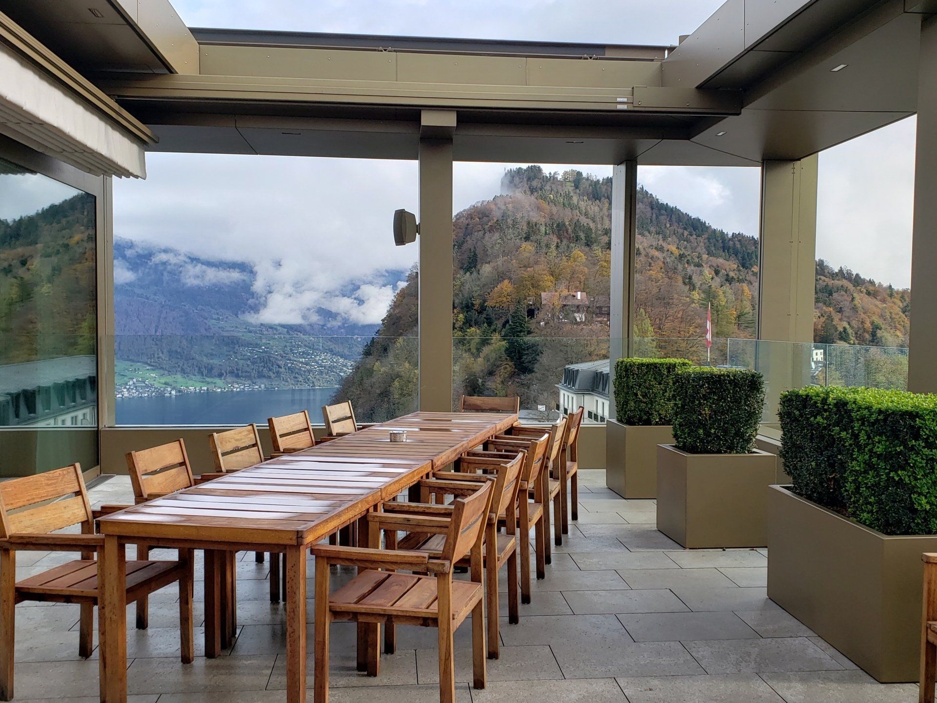 A long table and chairs on a patio with mountains in the background