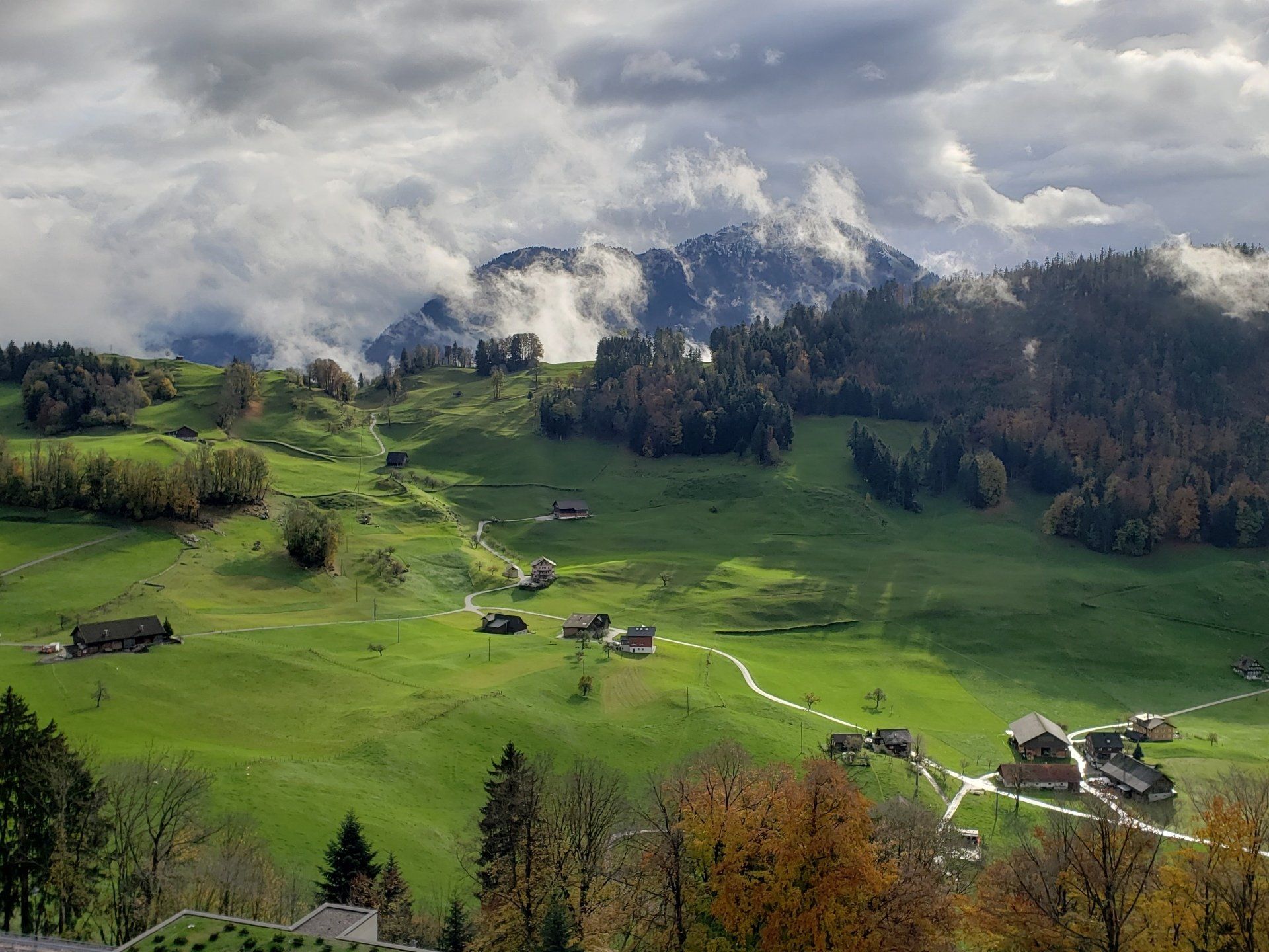 A valley with mountains in the background and clouds in the sky